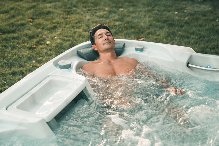 man in sundance spa enjoying the hot tub benefits