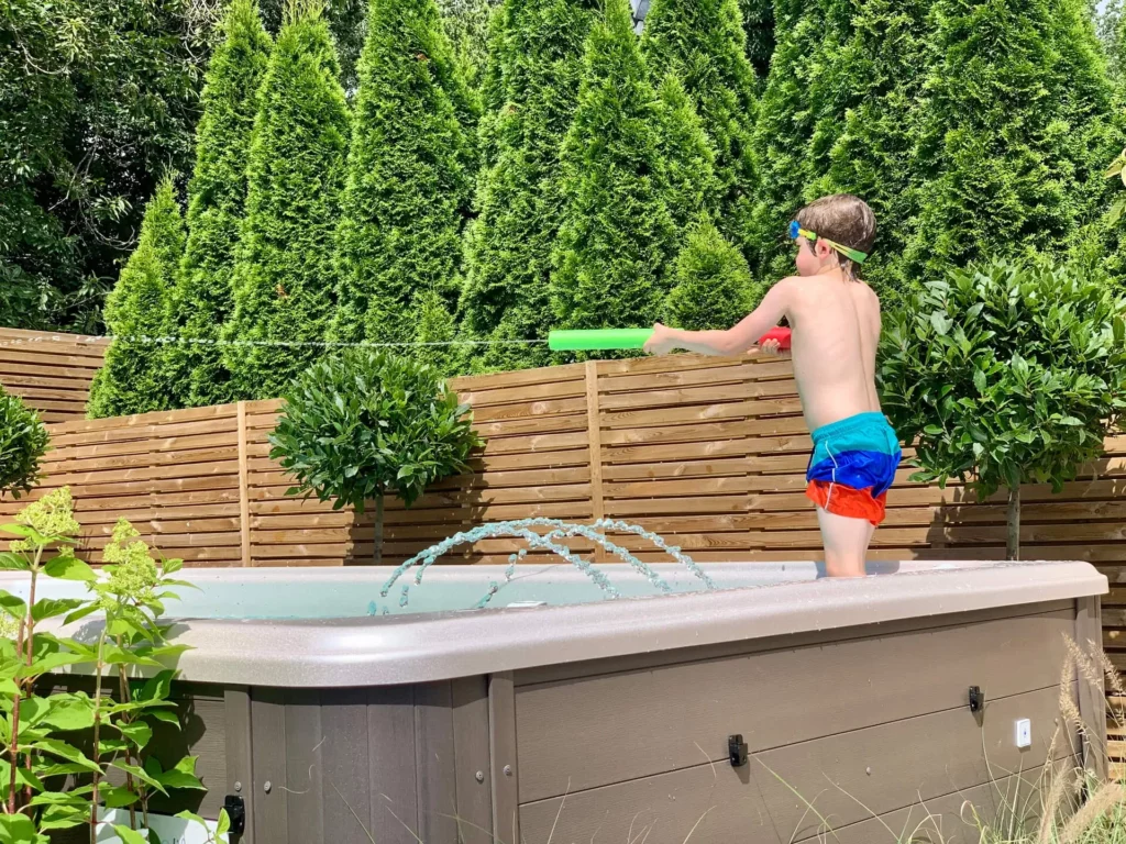 small swim spa in a backyard with a kid swimming